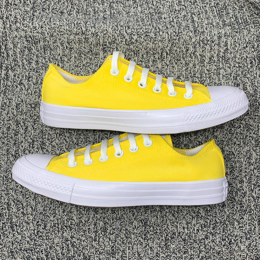 bright yellow low top converse laying on a knit blanket