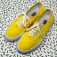 Yellow Laced Authentic Vans with a black sprinkle background