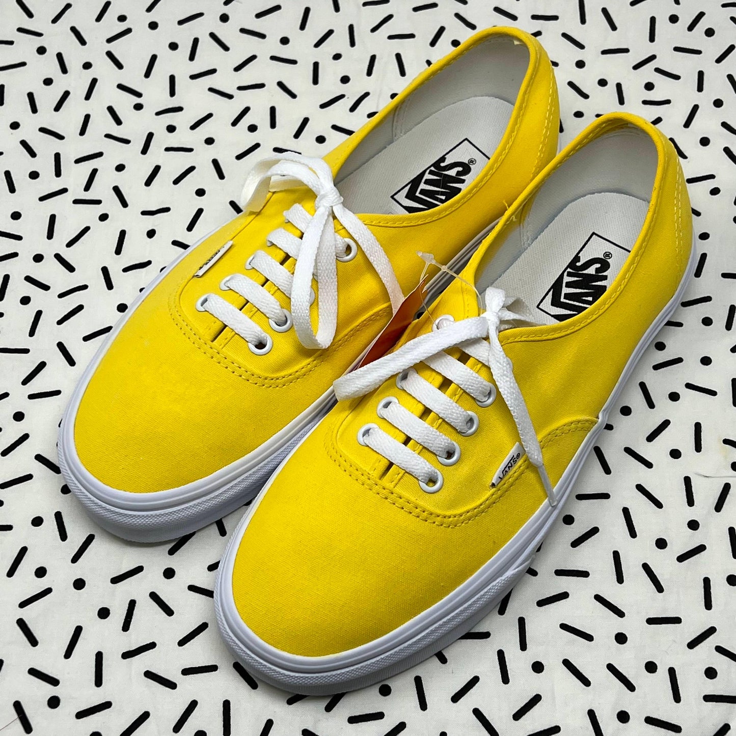 Yellow Laced Authentic Vans with a black sprinkle background